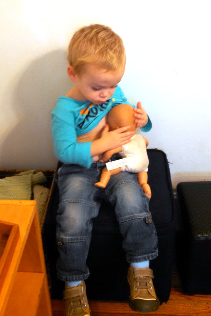 A boy playing, nursing a doll - WikimediaCommons